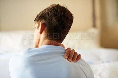 Buy stock photo Rearview shot of a young man suffering from a neck pain