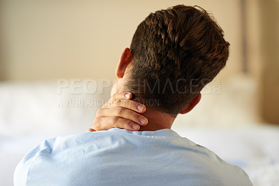 Buy stock photo Rearview shot of a young man suffering from a neck pain