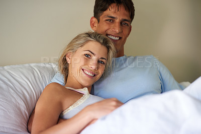 Buy stock photo Portrait of a young couple lying in bed