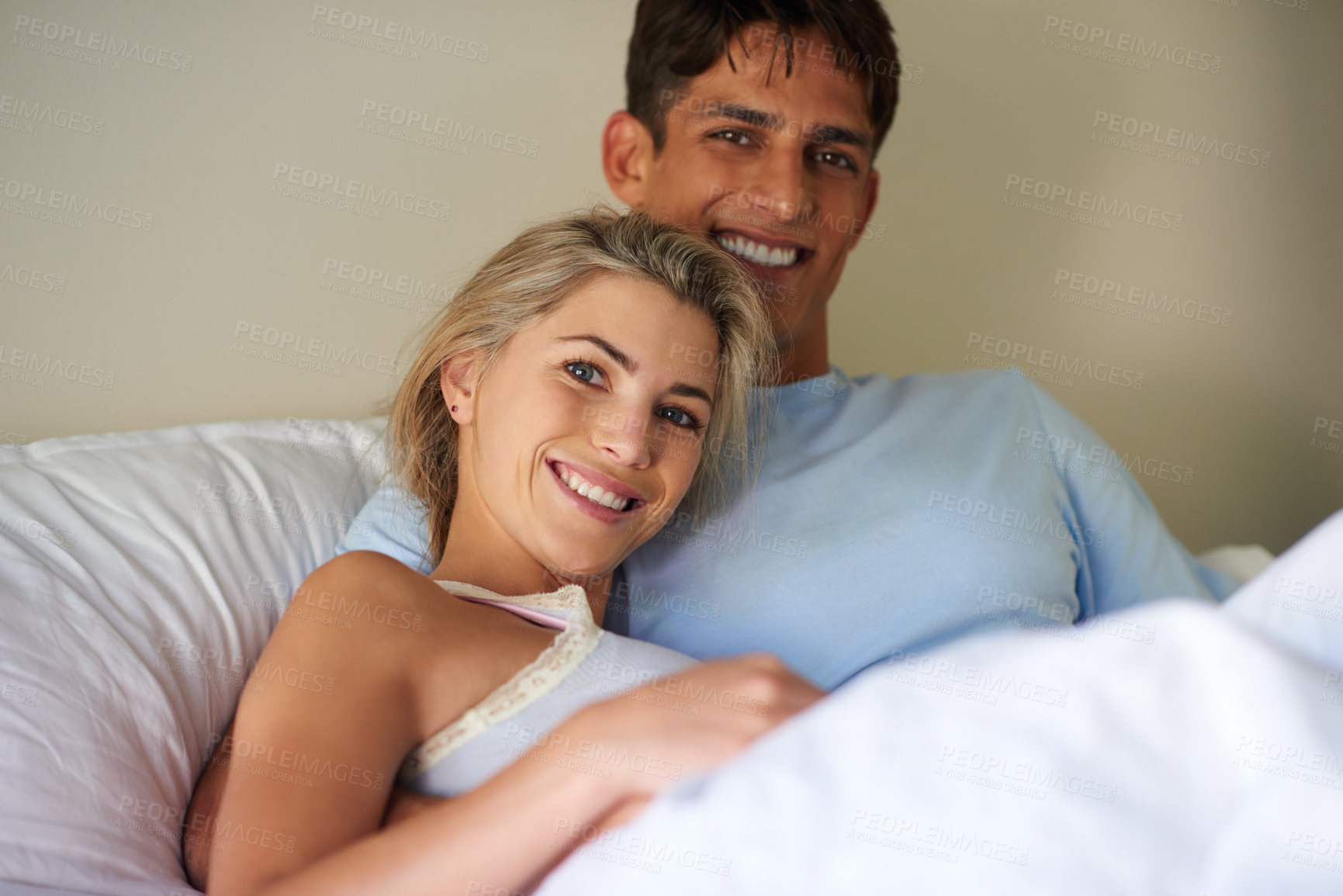 Buy stock photo Portrait of a young couple lying in bed