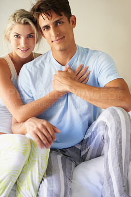 Buy stock photo Portrait of a happy young couple sitting on their bed