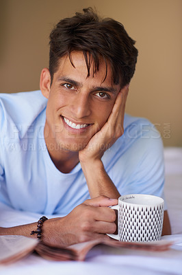 Buy stock photo Man, coffee and newspaper for portrait on bed, smile and info with update, story and article in home. Person, print media and tea cup to start morning with headlines, sports and economy in Greece