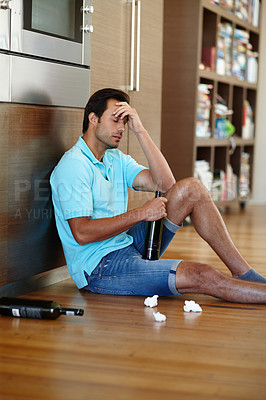 Buy stock photo Shot of a crying man drinking wine while sitting on the floor with some tissues