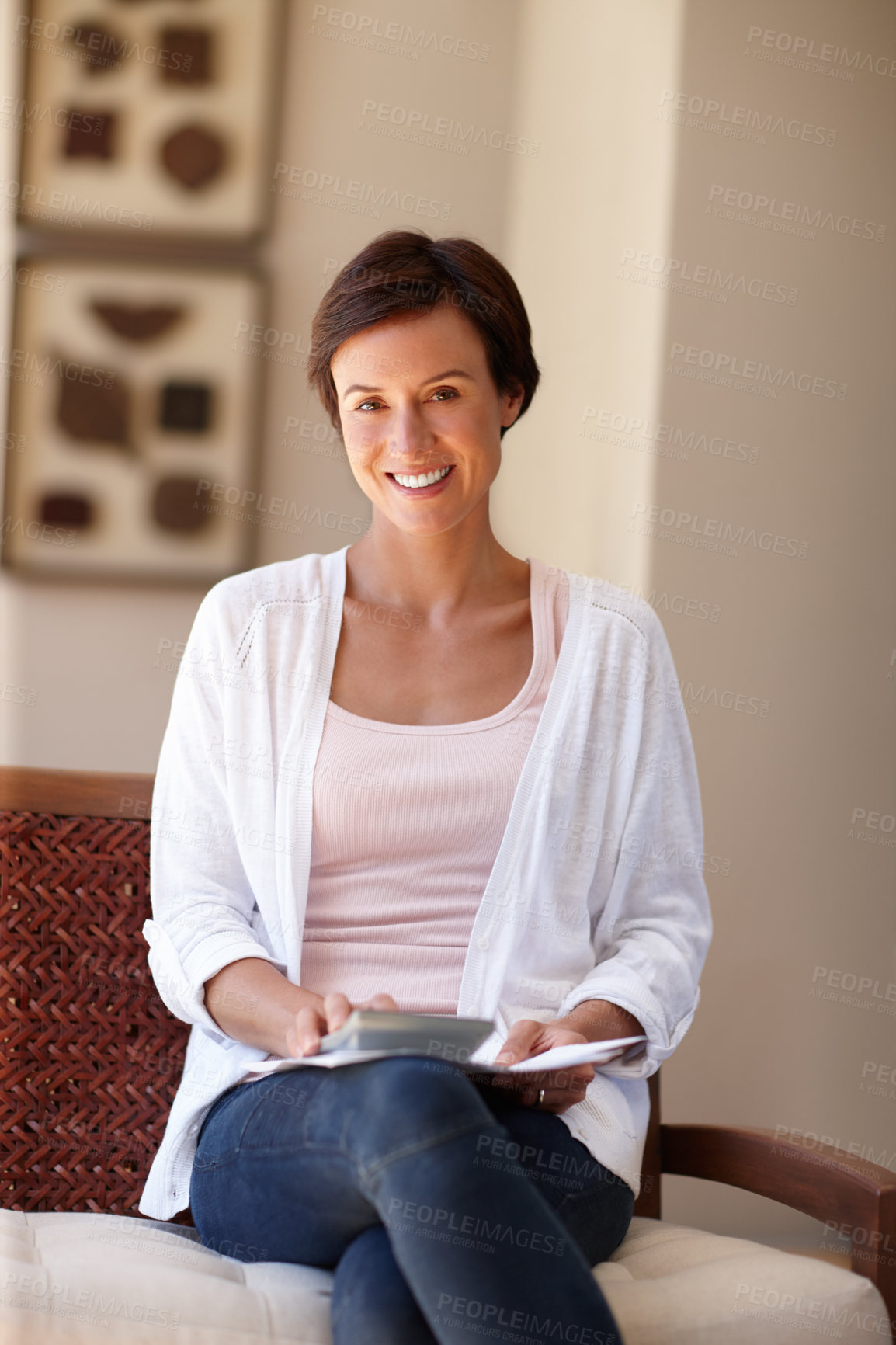 Buy stock photo Portrait of an attractive woman sitting with documents and a calculator at home