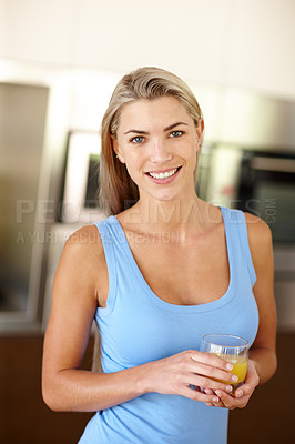 Buy stock photo Portrait of a beautiful young woman holding a glass of orange juice