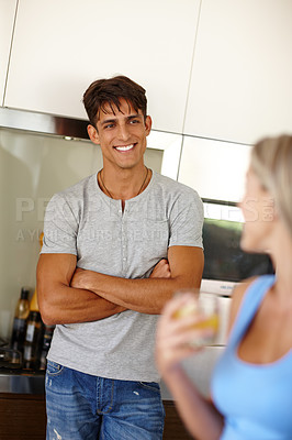 Buy stock photo Shot of a young couple chatting in the kitchen