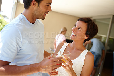 Buy stock photo Shot of a couple chatting while having a drink at a social gathering