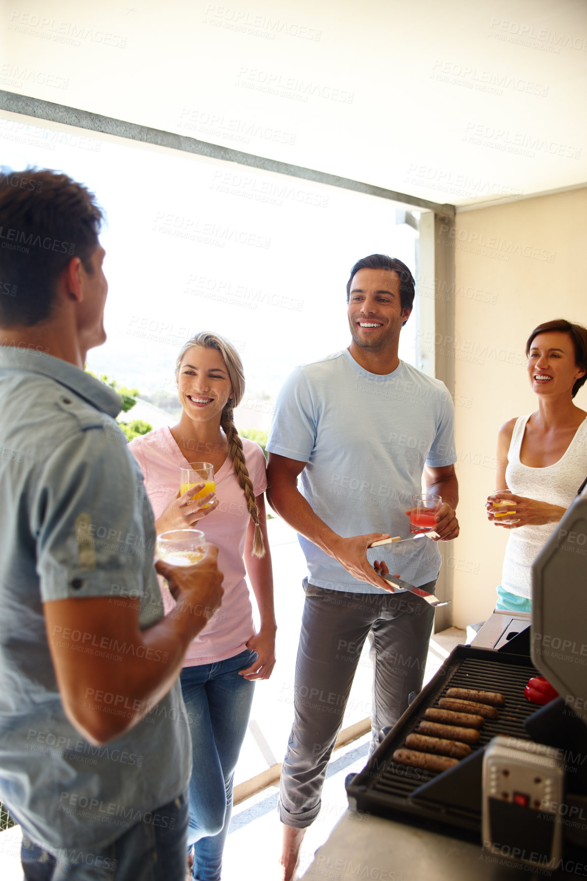 Buy stock photo Shot of a group of friends enjoying a barbeque over the weekend