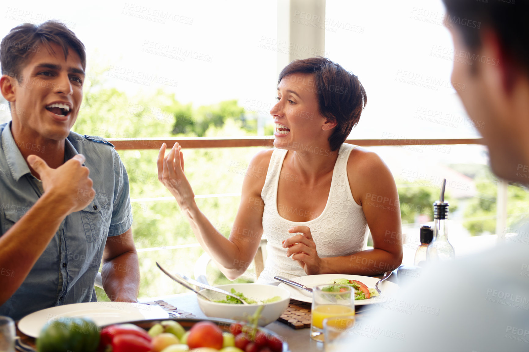 Buy stock photo Talking, salad and happy with friends at dining table for bonding, nutrition and vegetables. Health, love and lunch break with people eating at home for dishing food, meal prep and wellness together