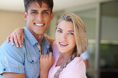 Buy stock photo Portrait of a beautiful young woman standing with her arm around her boyfriend