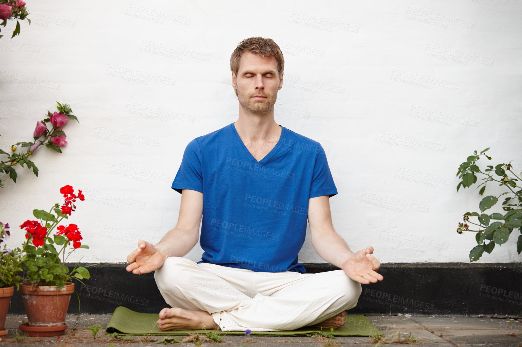 Buy stock photo Shot of a handsome mature man meditating in the lotus position in a courtyard