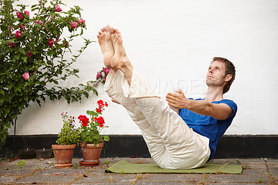 Buy stock photo Stretching, flowers and man with outdoor yoga exercise in backyard for fresh air in morning. Balance, health and person with reclined eagle crunches for workout in garden by floral plants at home.