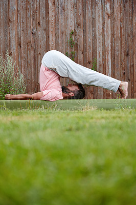 Buy stock photo Shot of a mature man doing yoga in his backyard