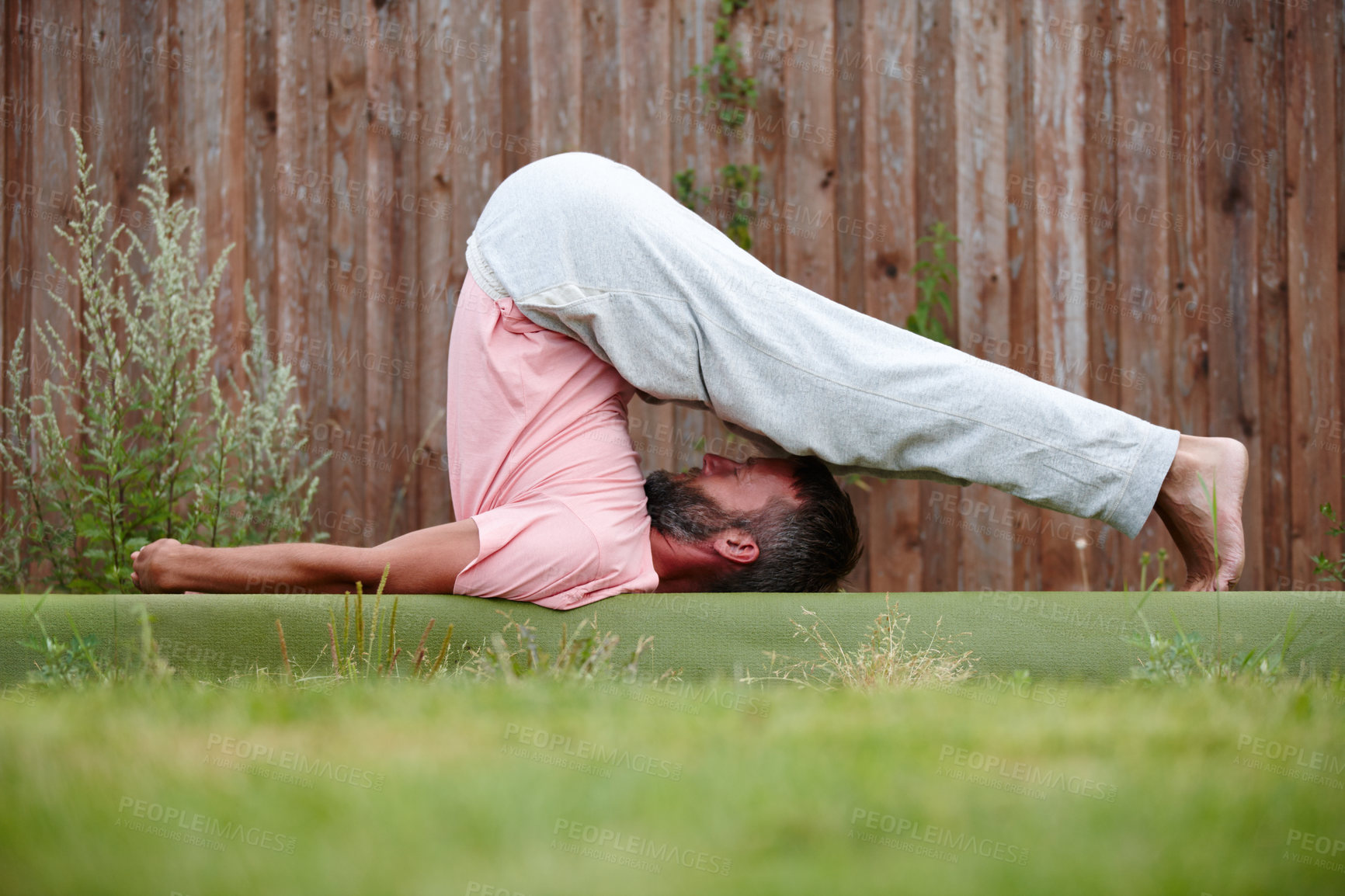 Buy stock photo Shot of a mature man doing yoga in his backyard