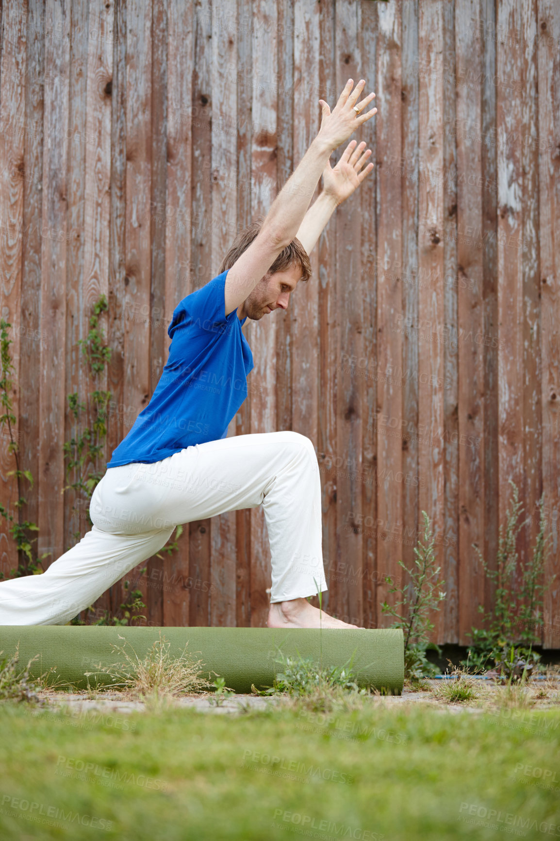 Buy stock photo Shot of a handsome man doing yoga in his backyard