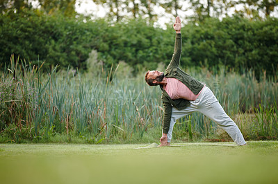 Buy stock photo Man, yoga and triangle pose on grass, nature and balance with mindfulness, wellness or peace at park. Mature person, zen and meditation in spring for stretching, breathing or pilates on lawn in Italy