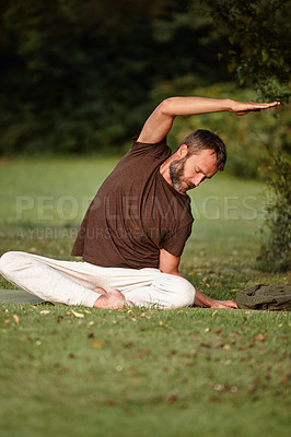 Buy stock photo Shot of a handsome mature man doing yoga in the outdoors