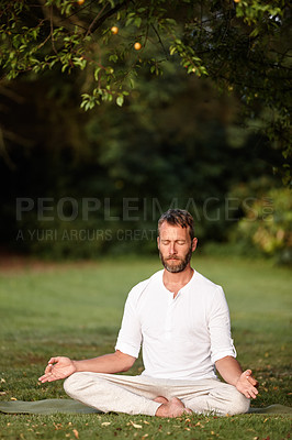 Buy stock photo Shot of a handsome mature man sitting in the lotus position with his eyes closed