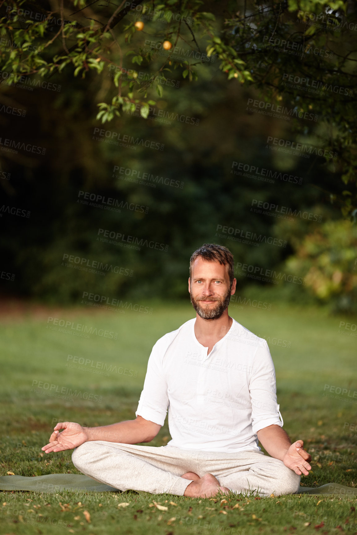 Buy stock photo Portrait of a handsome mature man sitting in the lotus position in nature