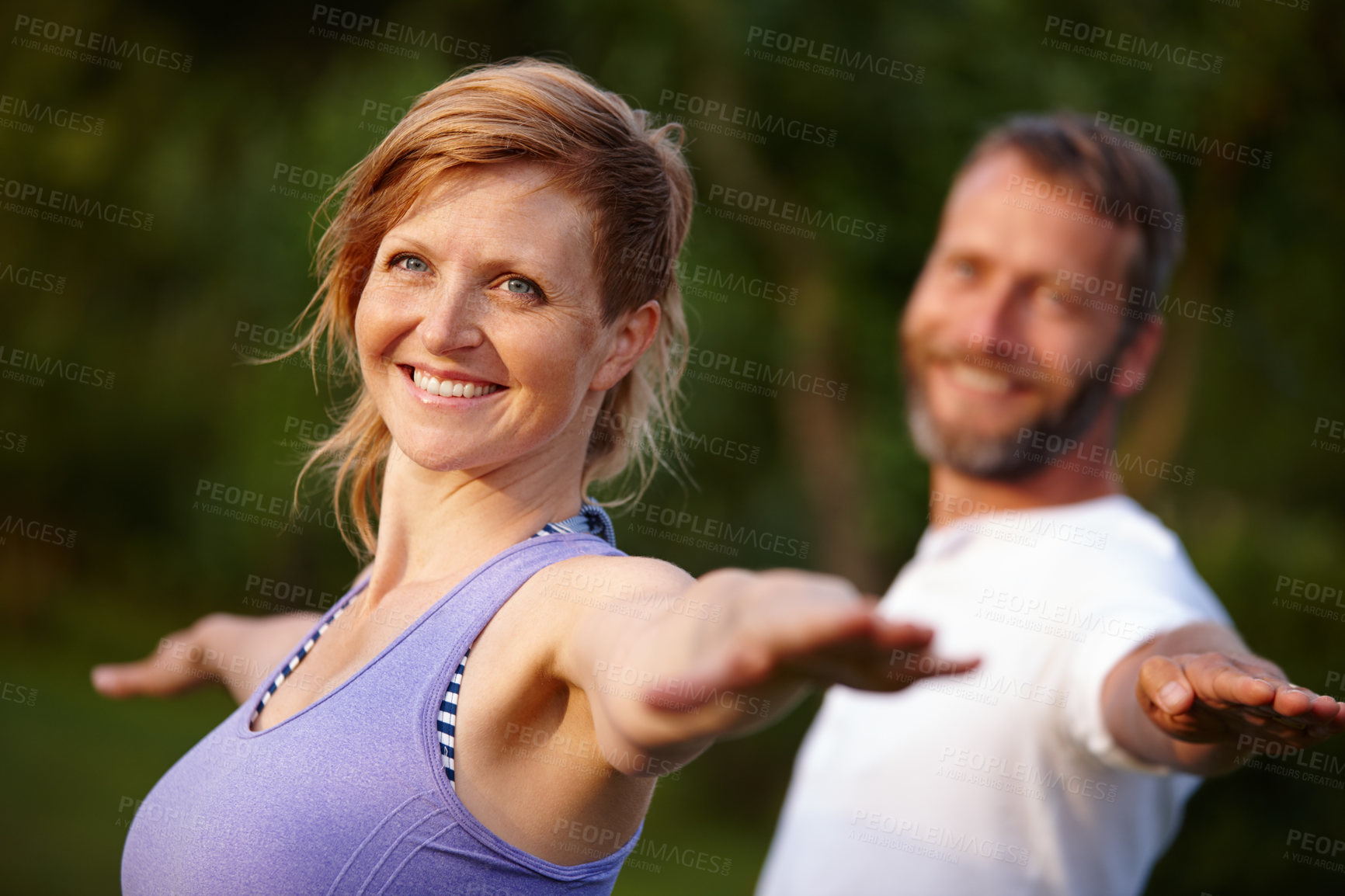 Buy stock photo Shot of an attractive woman doing yoga with her partner in the outdoors