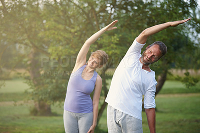 Buy stock photo Shot of a happy mature couple doing yoga in nature