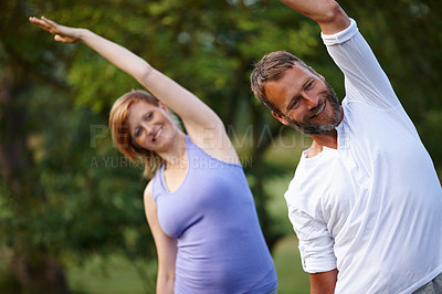 Buy stock photo Shot of a happy mature couple doing yoga in nature