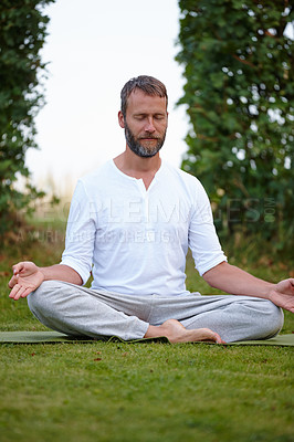 Buy stock photo Shot of a handsome mature man sitting in the lotus position with his eyes closed