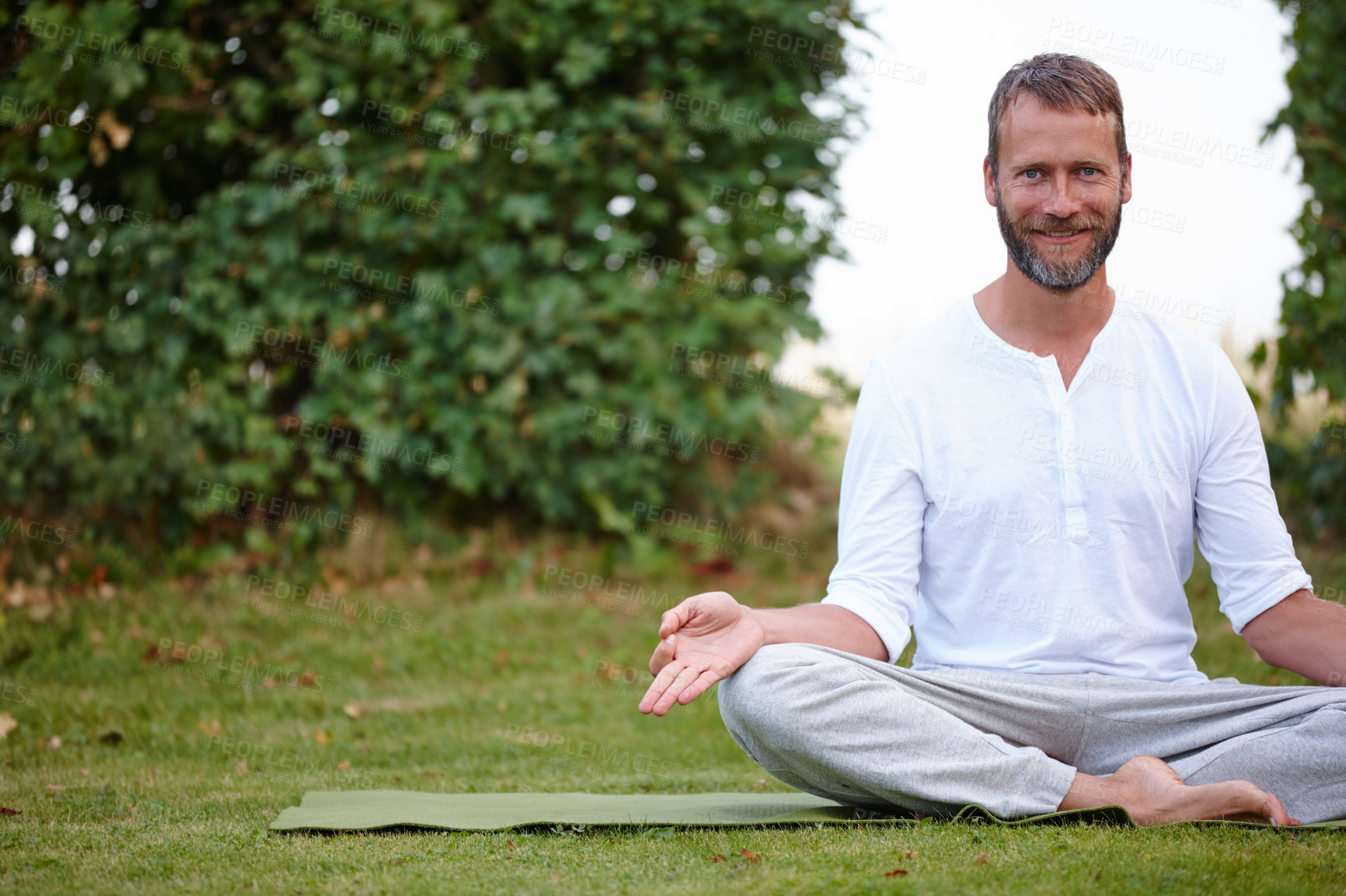 Buy stock photo Portrait of a handsome mature man smiling while doing yoga in the outdoors