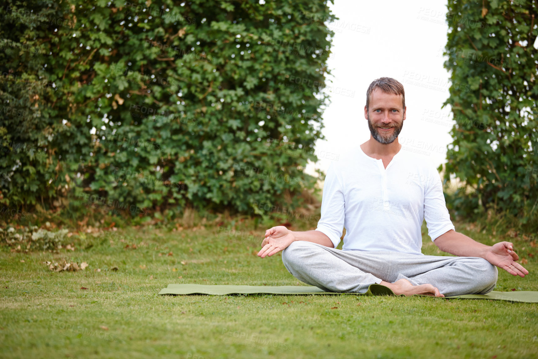 Buy stock photo Portrait of a handsome mature man smiling while doing yoga in the outdoors