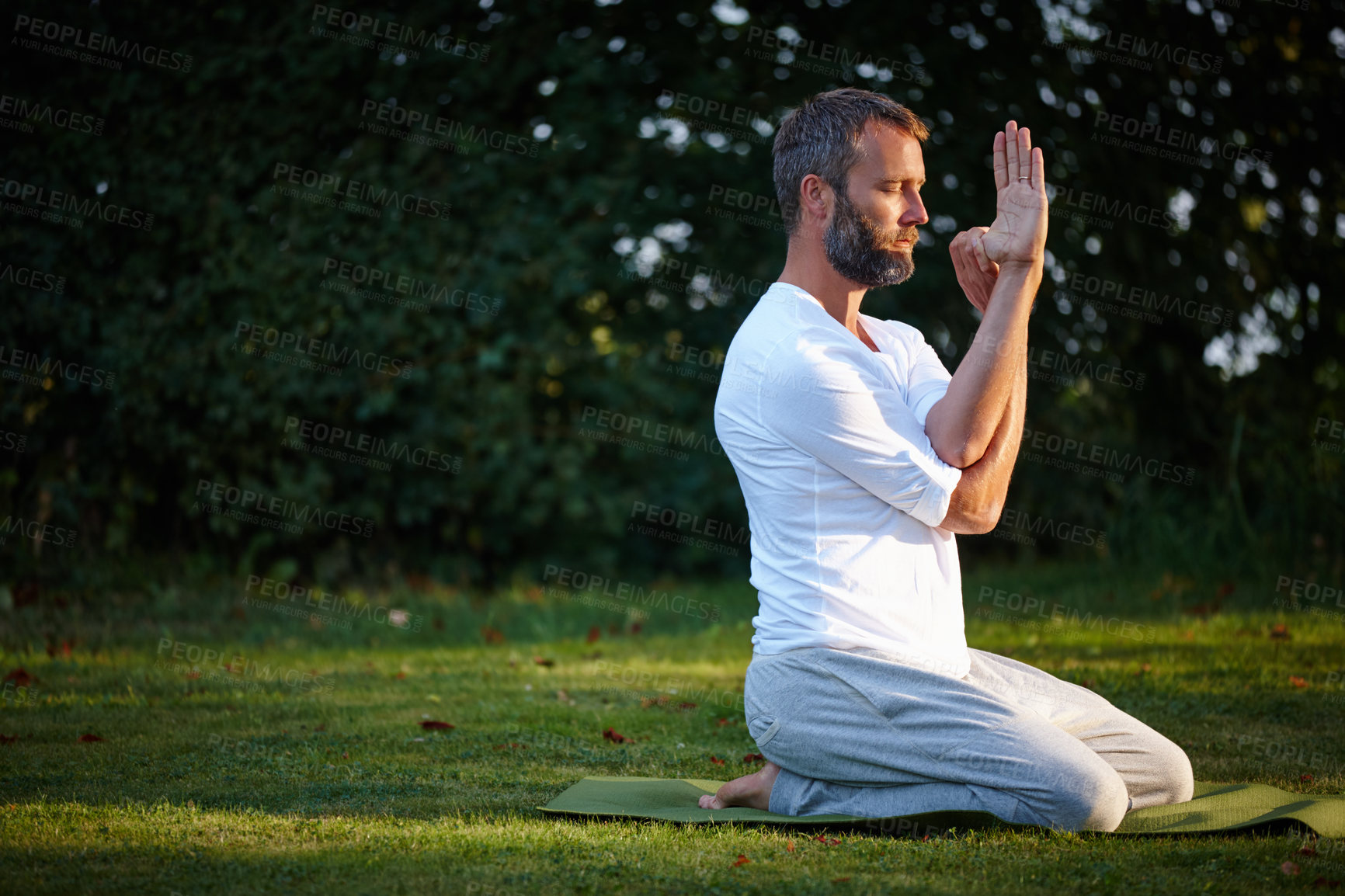 Buy stock photo Shot of a handsome mature man doing yoga in the outdoors