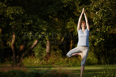 Buy stock photo Shot of an attractive woman enjoying a yoga session in nature