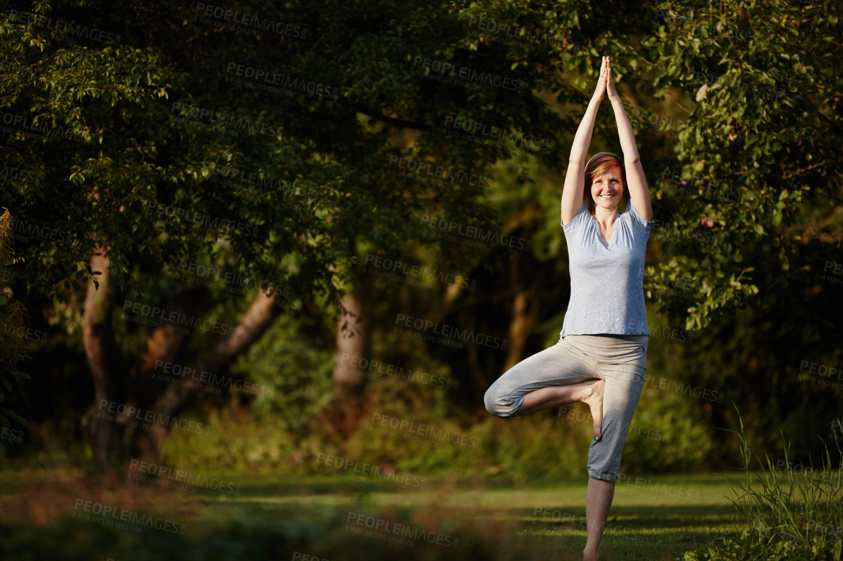 Buy stock photo Shot of an attractive woman enjoying a yoga session in nature