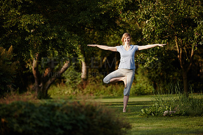 Buy stock photo Shot of an attractive woman enjoying a yoga session in nature