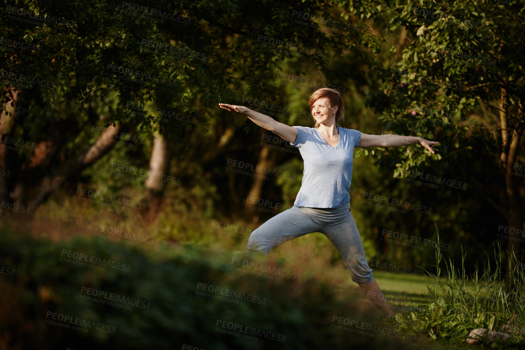 Buy stock photo Shot of an attractive woman doing yoga in the outdoors