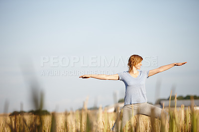 Buy stock photo Shot of an attractive woman doing yoga in a crop field