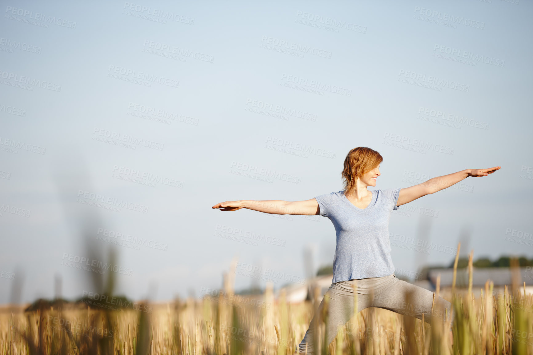 Buy stock photo Shot of an attractive woman doing yoga in a crop field