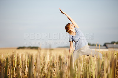 Buy stock photo Shot of an attractive woman doing yoga in a crop field