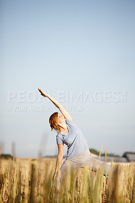 Buy stock photo Shot of an attractive woman doing yoga in a crop field