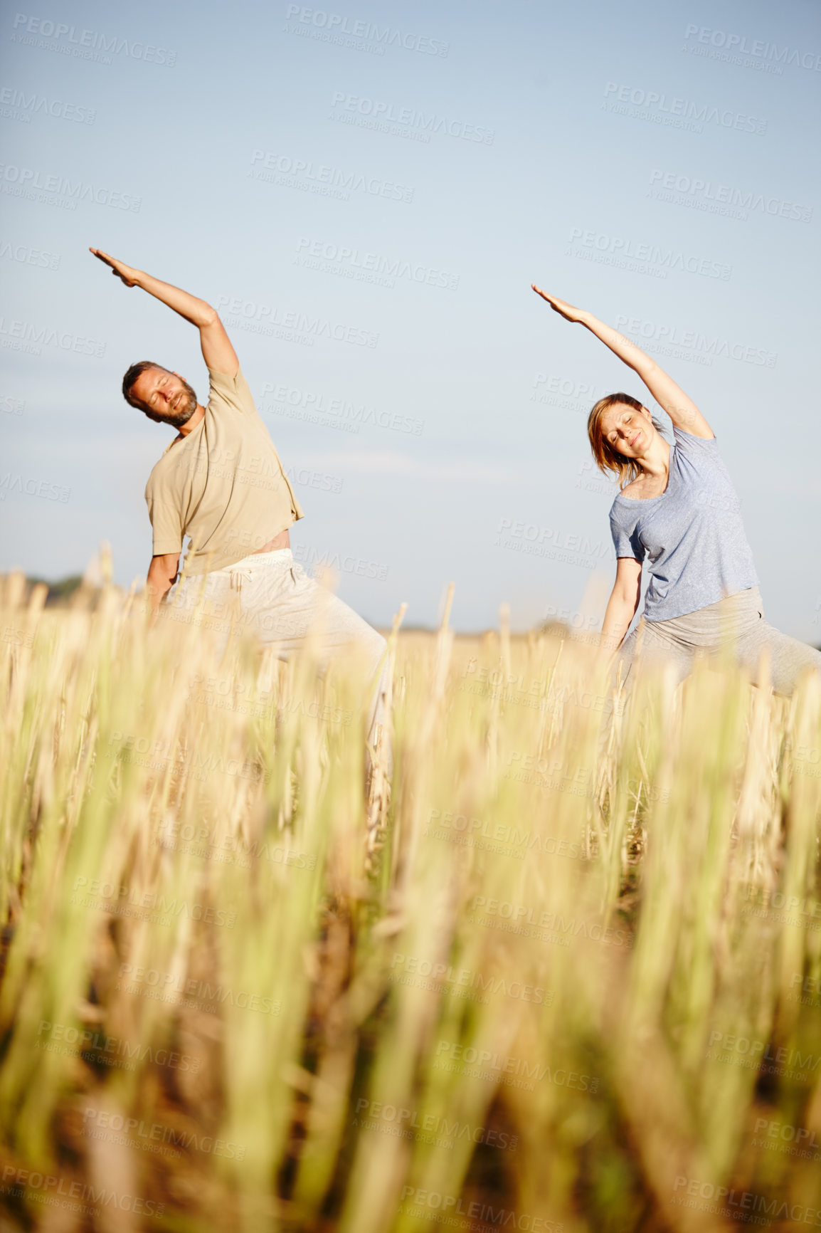 Buy stock photo Shot of a mature couple enjoying a yoga workout in a crop field