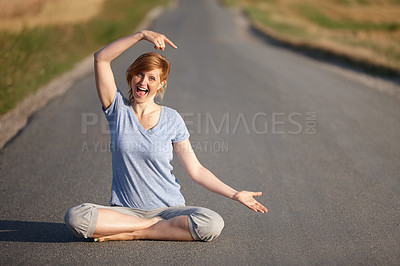 Buy stock photo Portrait of a woman looking excited while sitting in the lotus position on a country road