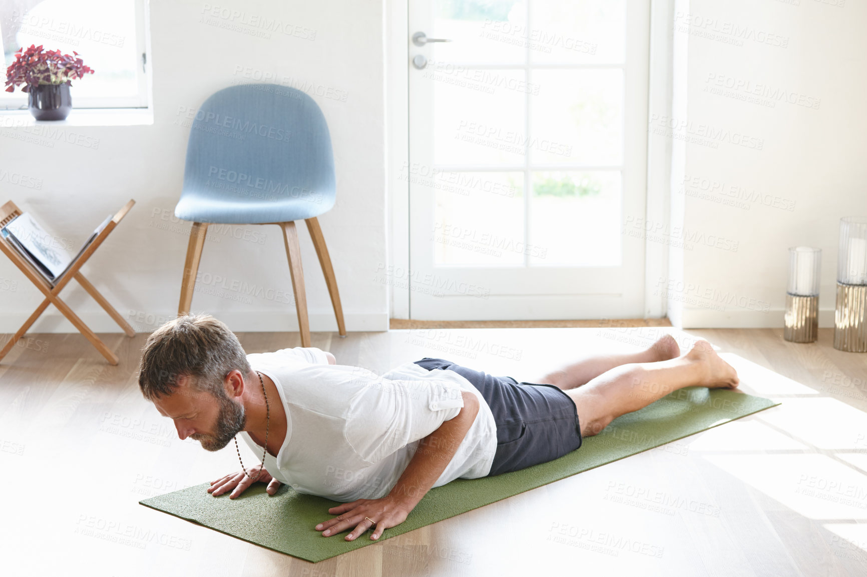 Buy stock photo Shot of a handsome mature man doing yoga at home