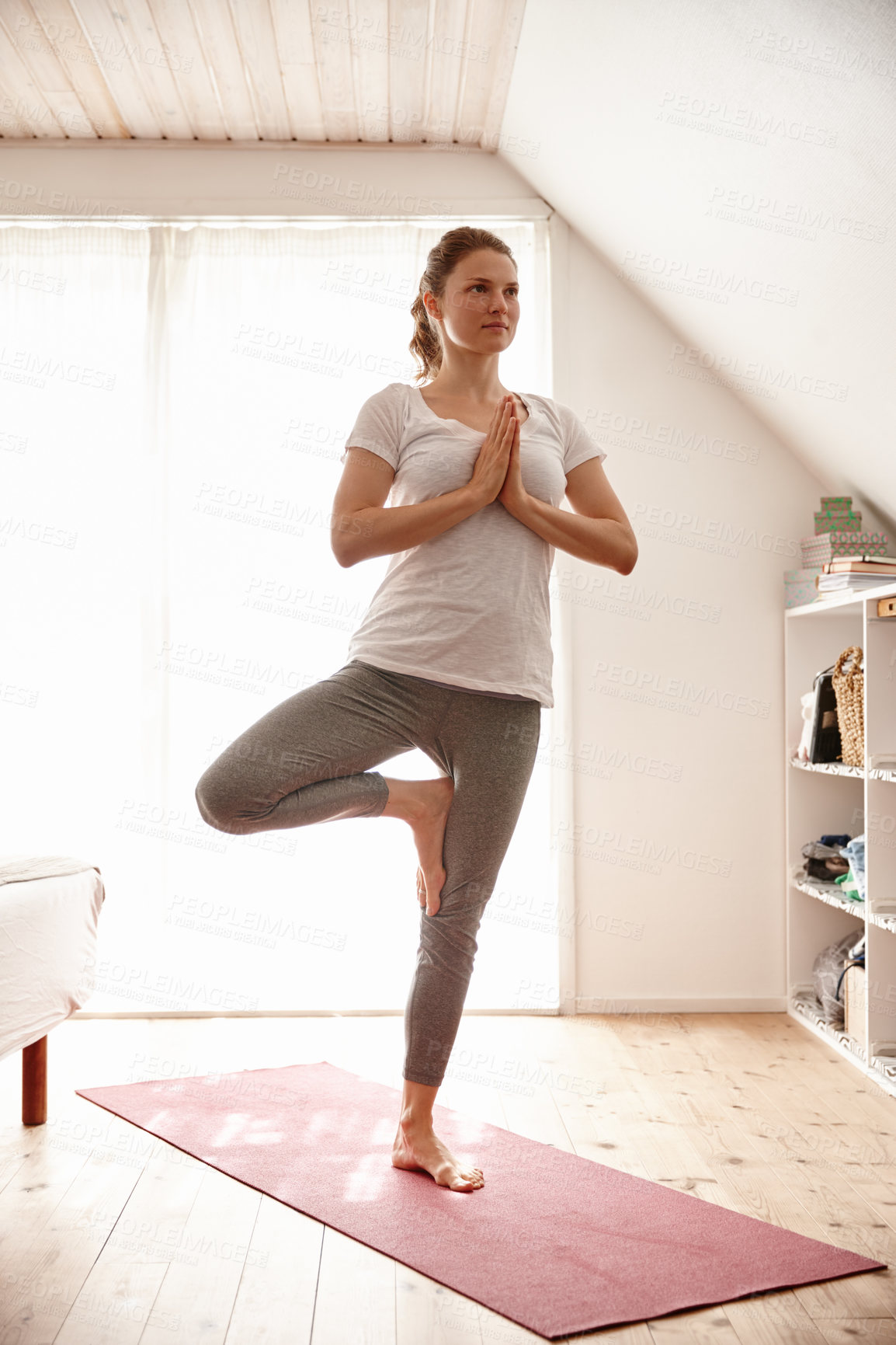 Buy stock photo Shot of an attractive young woman doing yoga at home