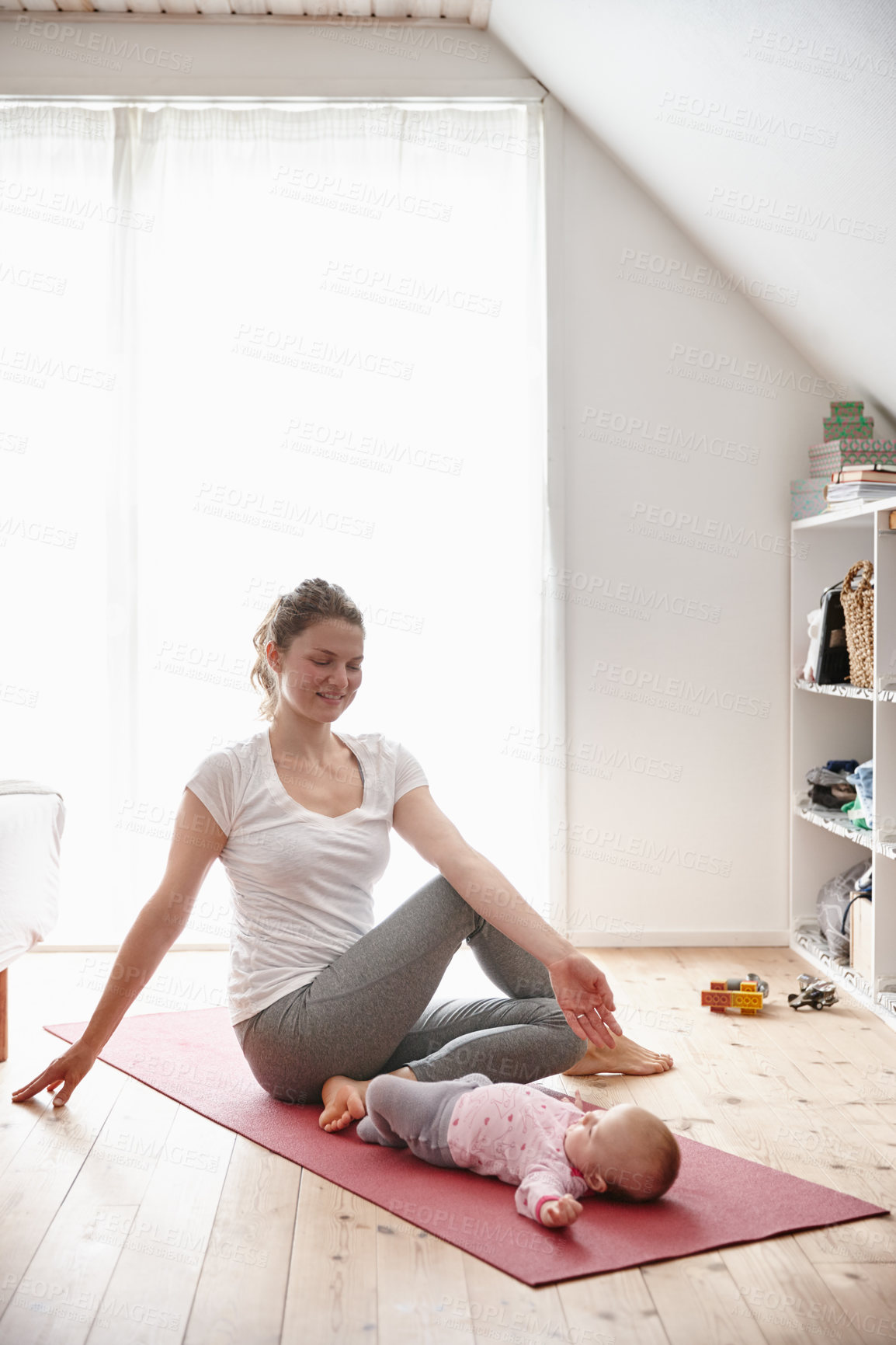 Buy stock photo Shot of an attractive young woman bonding with her baby girl while doing yoga