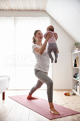 Buy stock photo Shot of an attractive young woman bonding with her baby girl while doing yoga