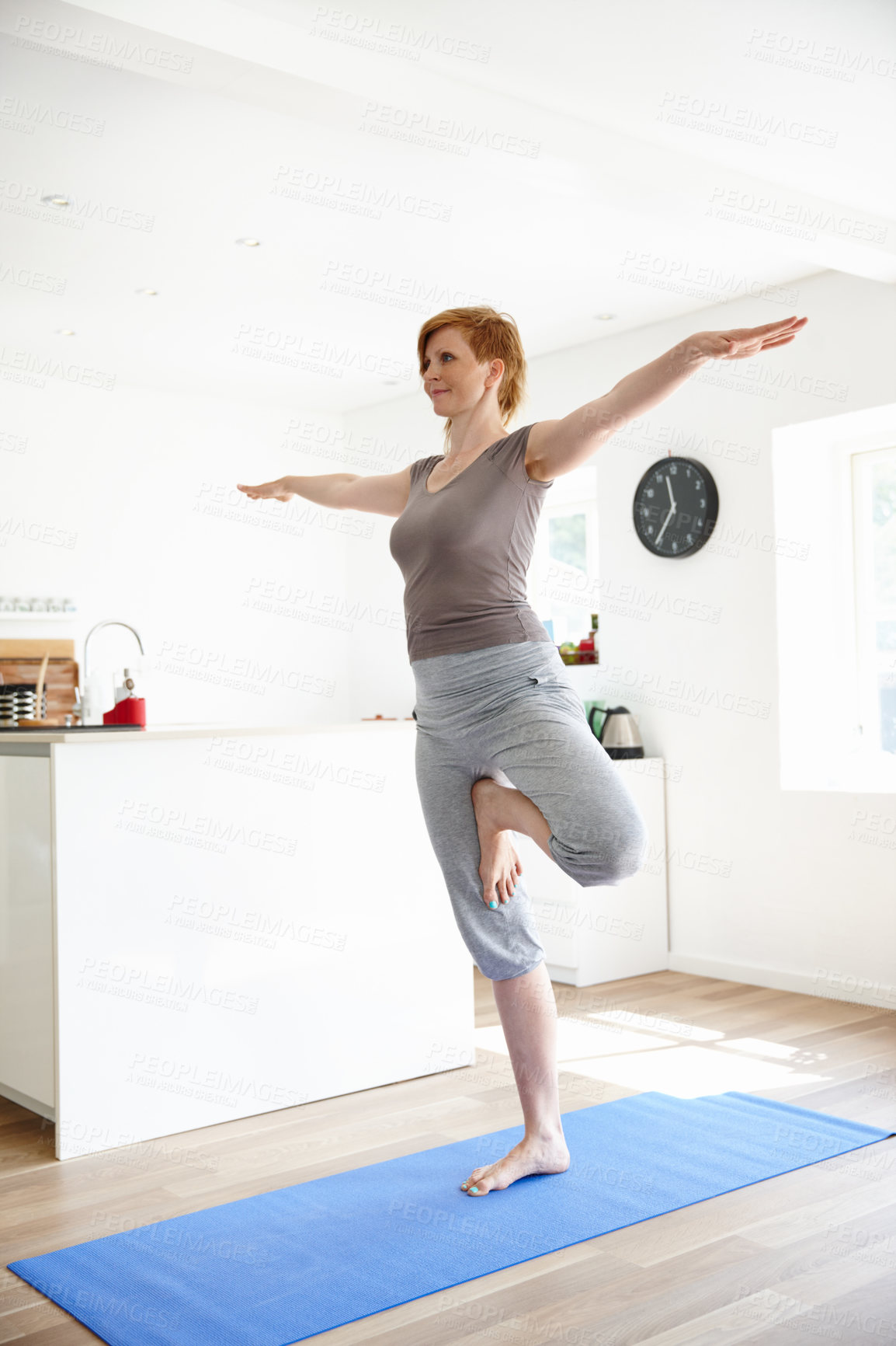 Buy stock photo Shot of an attractive woman doing yoga in her home