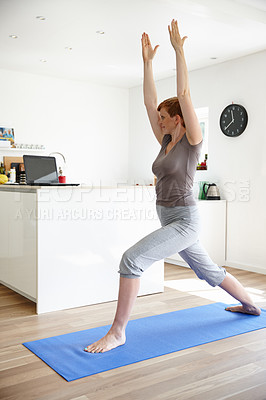 Buy stock photo Shot of an attractive woman doing yoga in her home