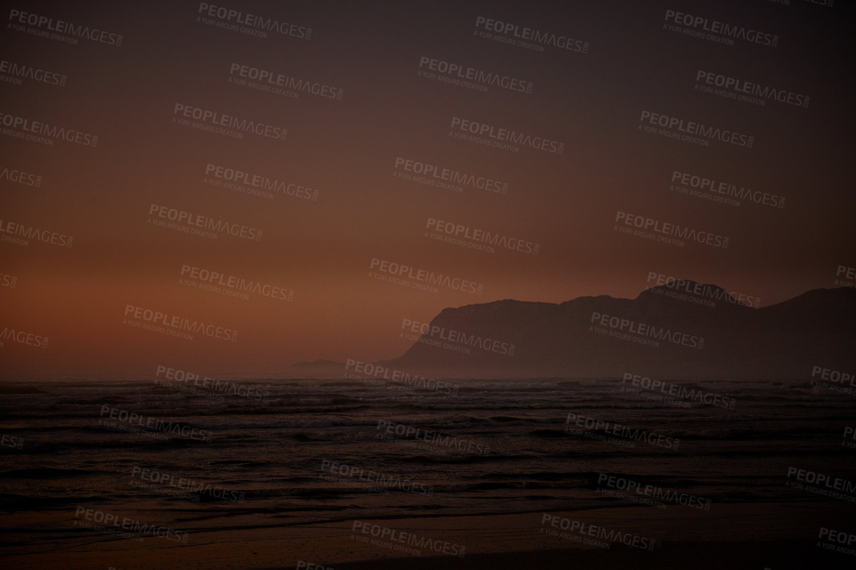 Buy stock photo Shot of ocean and distant mountains just before daybreak