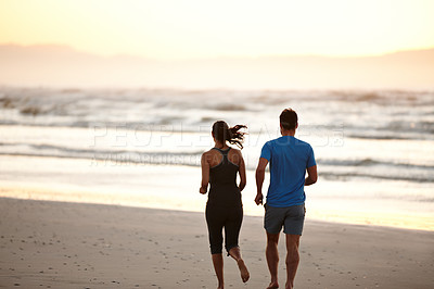Buy stock photo Rearview of a couple enjoying a beach run at daybreak