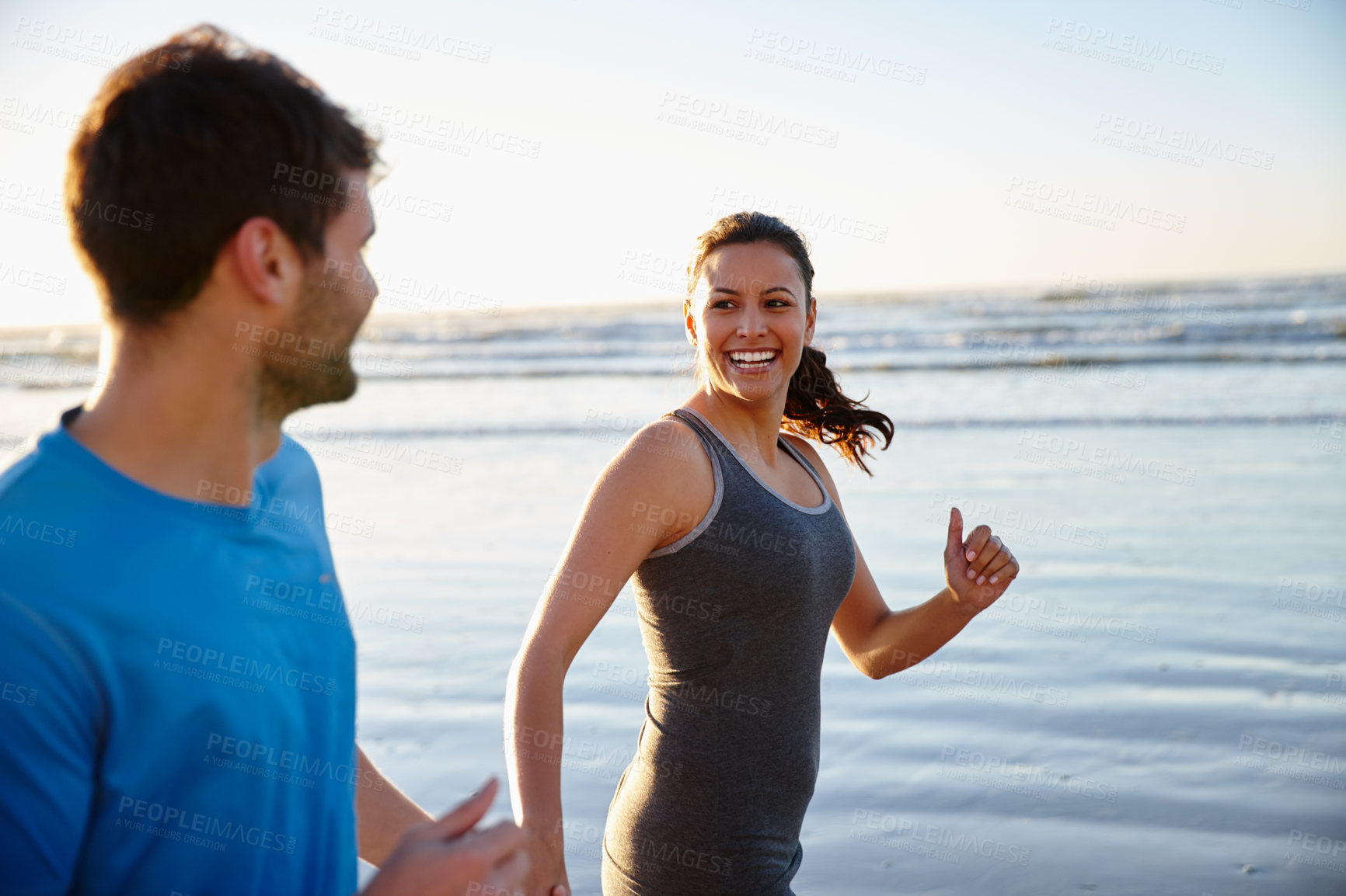 Buy stock photo Shot of a happy couple enjoying some exercise on the beach at sunrise