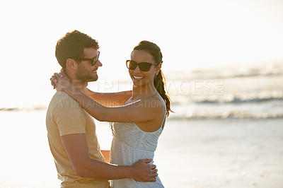 Buy stock photo Shot of a romantic young couple smiling with ocean in the background